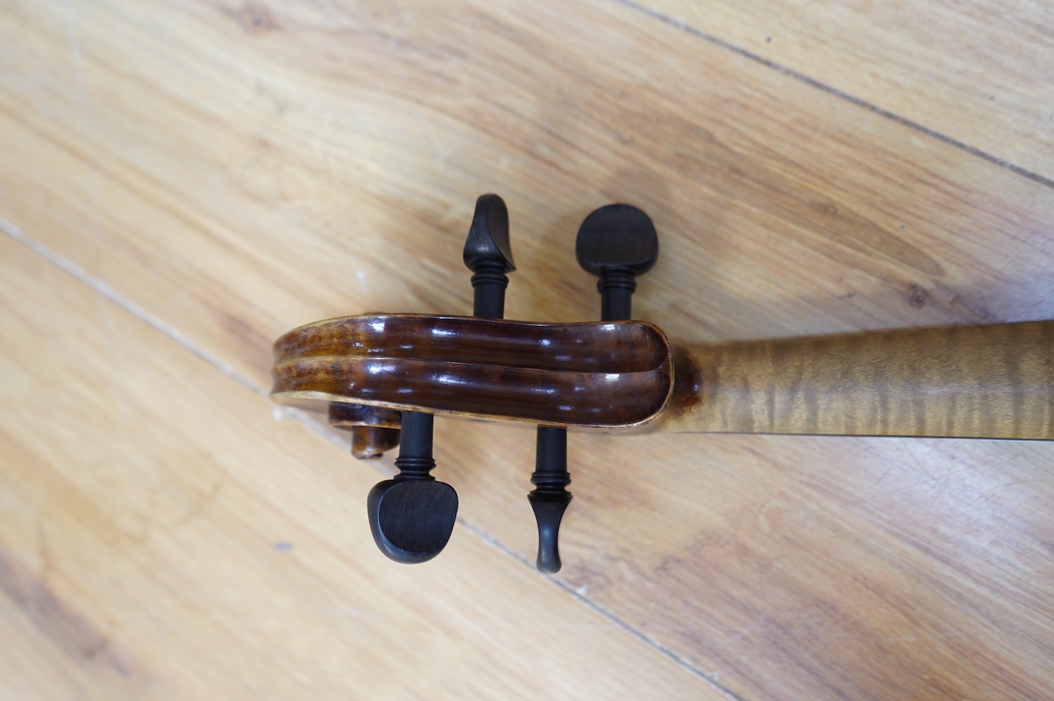 An early 20th century German violin, with a label reading ‘Copy of Joseph Guarnerius, Made in Germany’, body length 35.5cm, cased with a bow by Tourte. Condition - good.